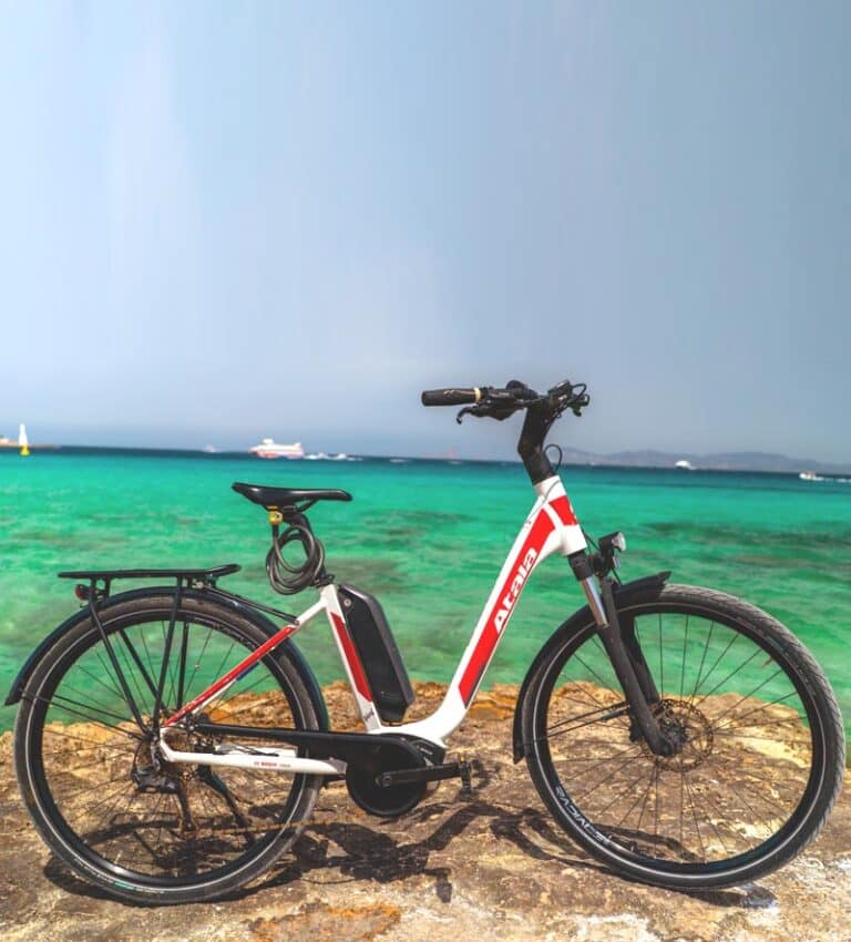 Bicicleta eléctrica de alquiler en Formentera frente al mar turquesa