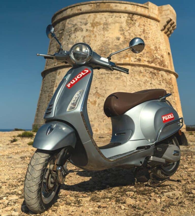 Vespa de alquiler en Formentera frente a la torre de Es Cap de Barbaria